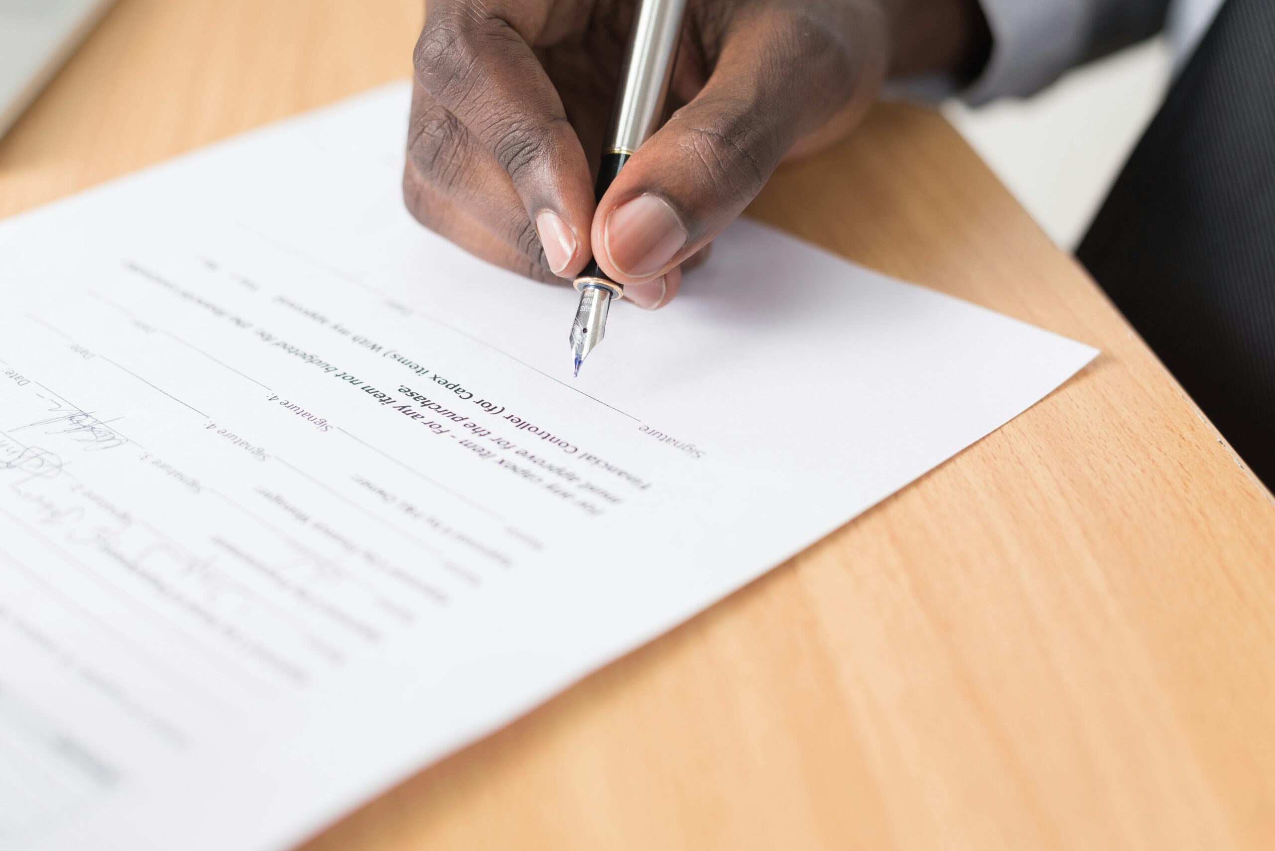 a man'hand signing the notary papers