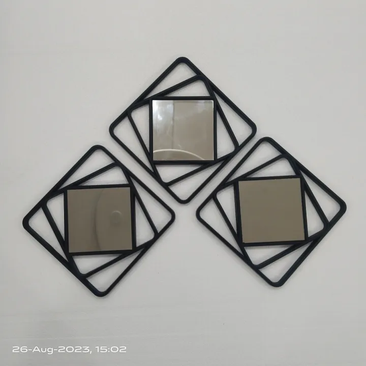 Set of three modern geometric wall mirrors with black metal square frames, arranged in a stylish pattern on a white wall